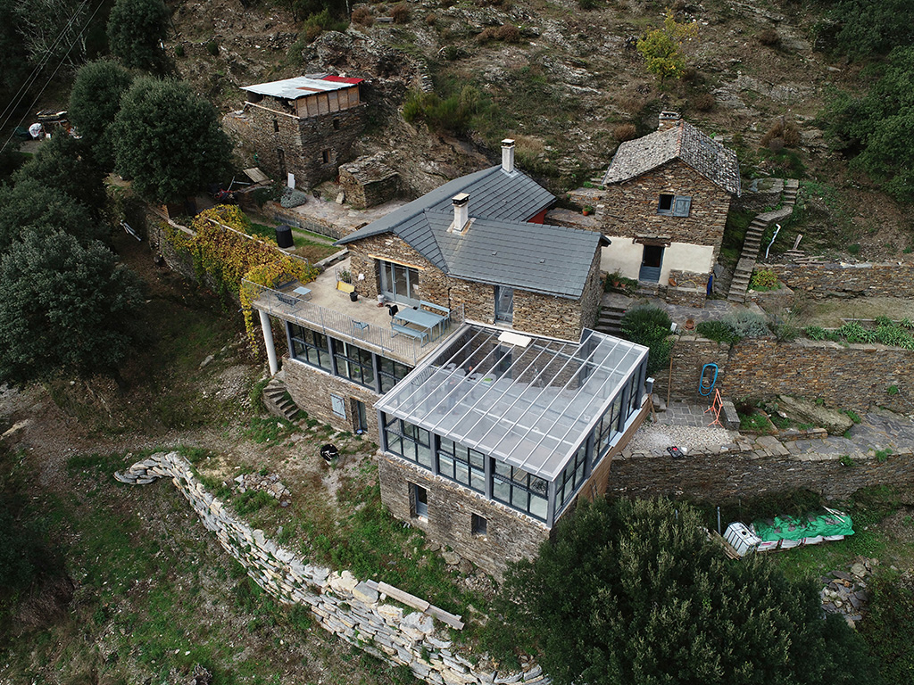 Maison en pierre rénovée avec extension moderne en verre et terrasse, projet d’architecte d’intérieur à Alès dans les Cévennes
